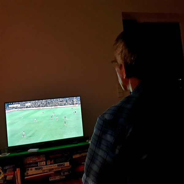 Mann schaut Fußball im Fernsehen