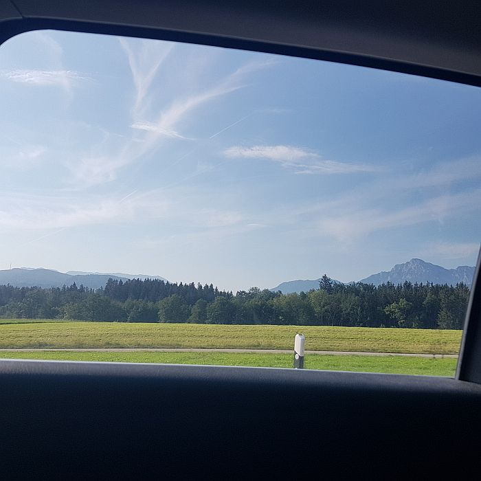 Blick auf Landschaft und blauen Himmel durch das Autofenster