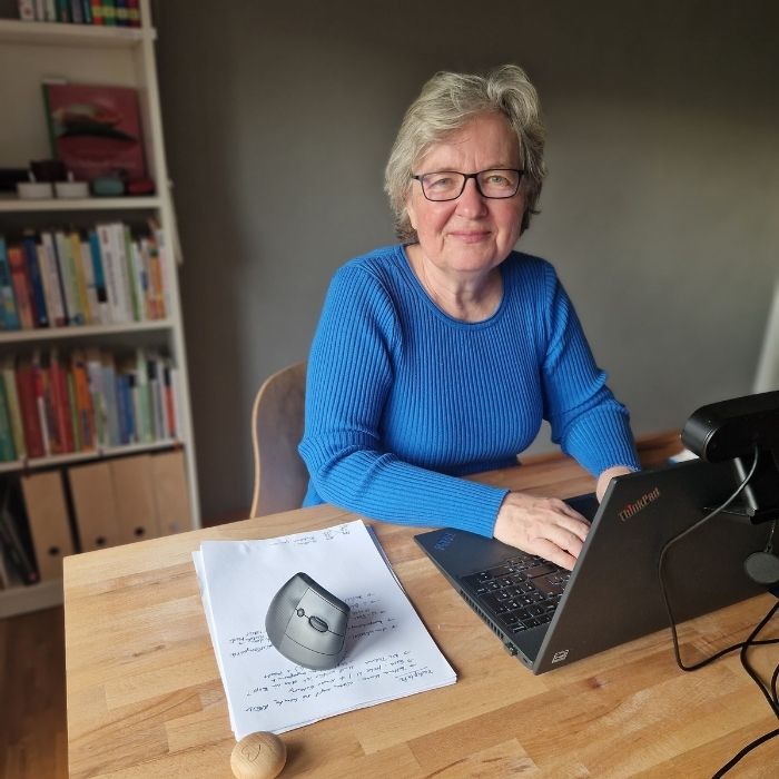 Frau im blauen Kleid am Laptop