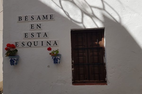 Hauswand mit spanischer Aufschrift "An dieser Ecke bitte küssen"